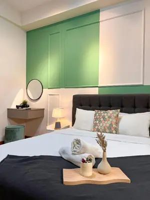 a bedroom with a large bed with a green wall at Modern Suites at Arte Mont Kiara BY Iconique in Kuala Lumpur