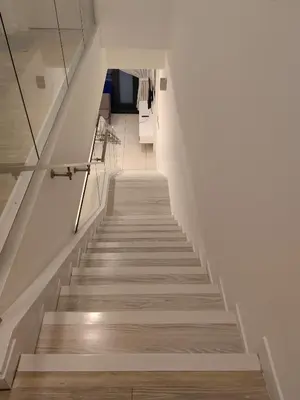 a staircase in a house with white walls and wooden floors at M City 2 DUPLEX BEDROOM KLCC in Kuala Lumpur