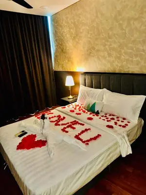 a bed with red rose petals on it at Vortex Suites klcc by Rit in Kuala Lumpur