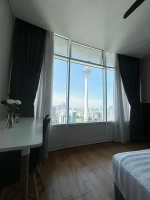 a hotel room with a desk and a view of a tower at Vortex Suites klcc by Rit in Kuala Lumpur