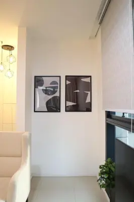 three pictures on a wall in a room with a chair at New Arcoris 6 Pax 2 BR with Pool View Mont Kiara - BOHO in Kuala Lumpur