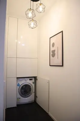 a laundry room with a washing machine and a picture at New Arcoris 6 Pax 2 BR with Pool View Mont Kiara - BOHO in Kuala Lumpur