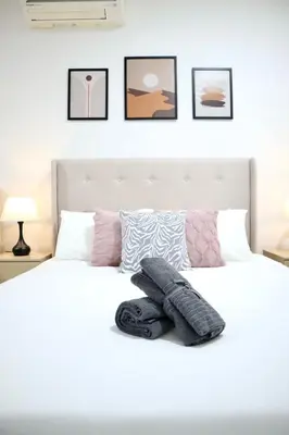 a bedroom with a white bed with pillows on it at New Arcoris 6 Pax 2 BR with Pool View Mont Kiara - BOHO in Kuala Lumpur