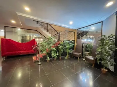 a lobby with a red couch and a bunch of plants at Rae Hotel Bukit Bintang in Kuala Lumpur