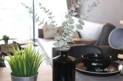 a black vase with a plant in it on a table at Modern Suites 3Beds at Continew, TRX KLCC view, Next to IKEA in Kuala Lumpur