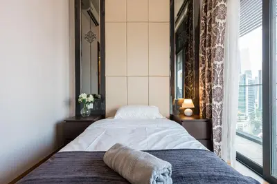 a bedroom with a bed and a large window at Dorsett Residence Kuala Lumpur 15 in Kuala Lumpur