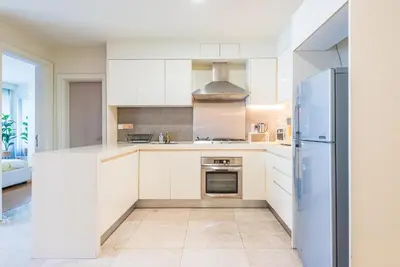 a kitchen with white cabinets and a refrigerator at 2min walk to Lot 10, 5 min to Pavillion 2BR 8-2 WIFI 100mbps in Kuala Lumpur