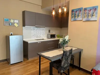 a small kitchen with a table and a refrigerator at Luxury Regalia suites by adnan in Kuala Lumpur