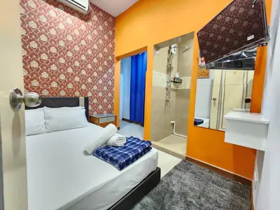 a small room with a bed and a shower at Holiday Hostel KLCC in Kuala Lumpur