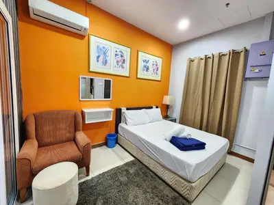 a small room with a bed and a chair at Holiday Hostel KLCC in Kuala Lumpur
