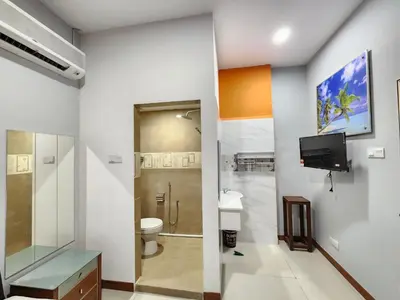a bathroom with a toilet and a tv on the wall at Holiday Hostel KLCC in Kuala Lumpur