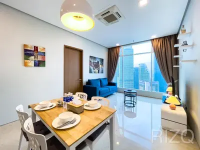 a dining room and living room with a table and chairs at SOHO SUITES KLCC by Wonder Home in Kuala Lumpur