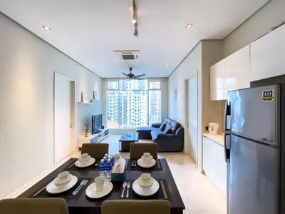 a kitchen and living room with a table and a refrigerator at SOHO SUITES KLCC by Wonder Home in Kuala Lumpur