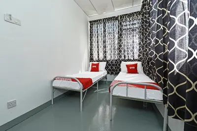 a room with two beds with red pillows in it at Hotel O Sri Rampai Metro Hostel in Kuala Lumpur