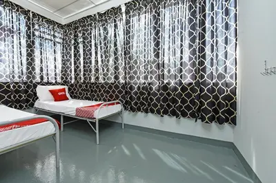 a room with black and white wallpaper and a bed and a table at Hotel O Sri Rampai Metro Hostel in Kuala Lumpur