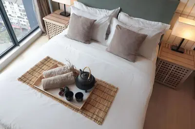 a white bed with a tray of food on it at Modern Designer Suite at Continew, TRX KLCC View, Next to IKEA in Kuala Lumpur