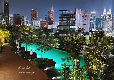a swimming pool with a city skyline in the background at Modern Designer Suite at Continew, TRX KLCC View, Next to IKEA in Kuala Lumpur