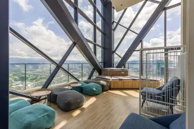a room with large windows and blue chairs at Continew Residensi by Airhost in Kuala Lumpur