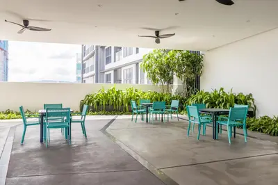 a patio with blue chairs and tables in a building at Continew Residensi by Airhost in Kuala Lumpur