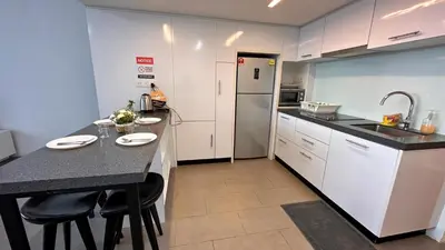 a kitchen with a black counter top and white cabinets at KL Sentral Loft, EST Bangsar #6, LRT in Kuala Lumpur