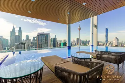 a swimming pool with tables and chairs and a city skyline at The Colony & The Luxe, Kuala Lumpur by Canopy Lives in Kuala Lumpur