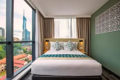 a bedroom with a large bed and a large window at Santa Grand Signature Kuala Lumpur in Kuala Lumpur