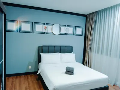 a bedroom with a white bed with a blue wall at Mercu Summer Suites KLCC by Star Residence in Kuala Lumpur