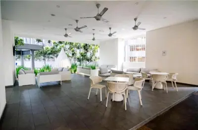 a large living room with tables and white chairs at 188 Suites KLCC by Signature Apartment in Kuala Lumpur