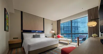 a hotel room with a bed and a large window at Amari Kuala Lumpur in Kuala Lumpur