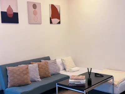 a living room with a blue couch and a table at 6PAX SUITES KL CITY Pavilion at Bukit Bintang NETFLIX & WIFI in Kuala Lumpur