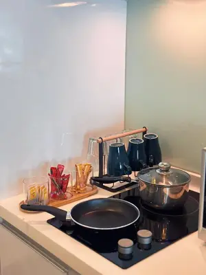 a kitchen counter with a stove with pots and pans at 6PAX SUITES KL CITY Pavilion at Bukit Bintang NETFLIX & WIFI in Kuala Lumpur