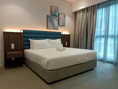 a bedroom with a large bed with a blue headboard at The Ooak Suites and Residence@ Kiara 163 in Kuala Lumpur