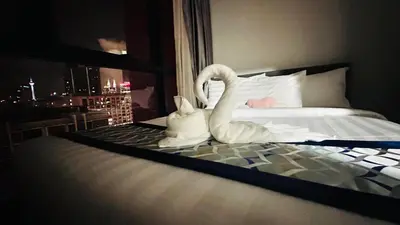 two swans sitting on a bed in a hotel room at Velocity Residence at Sunway mall in Kuala Lumpur