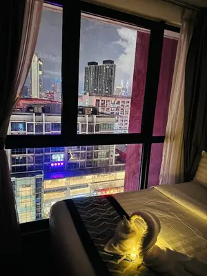 a bedroom with a view of a city from a window at Velocity Residence at Sunway mall in Kuala Lumpur
