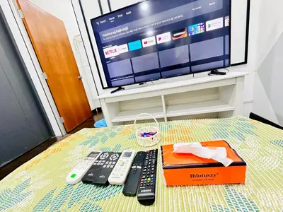 a table with remotes and a box and a tv at Velocity Residence at Sunway mall in Kuala Lumpur