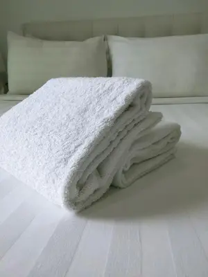 a white blanket sitting on top of a bed at Oneiro One Bukit Ceylon in Kuala Lumpur
