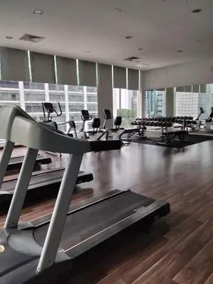 a gym with a row of treadmills and ellipticals at Oneiro One Bukit Ceylon in Kuala Lumpur