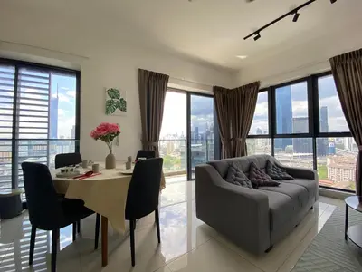 a living room with a table and a couch at Happy Continew Residence 2 Bedrooms - TRX KL in Kuala Lumpur
