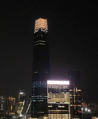 a tall building is lit up at night at Happy Continew Residence 2 Bedrooms - TRX KL in Kuala Lumpur