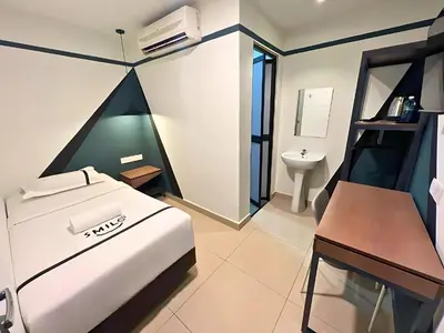 a bedroom with a bed and a desk and a sink at Smile Hotel Titiwangsa Pekeliling Sentul in Kuala Lumpur