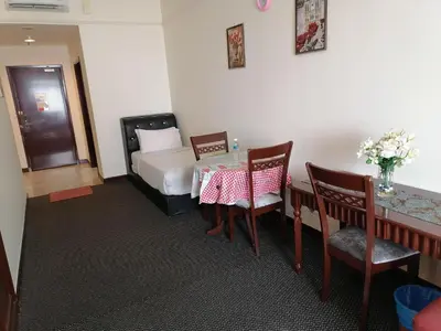a room with a table and a bed and a table and chairs at KL BERJAYA TIMES SQUARE SERVICe APARTMENT in Kuala Lumpur