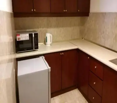 a kitchen with a white refrigerator and a microwave at KL BERJAYA TIMES SQUARE SERVICe APARTMENT in Kuala Lumpur