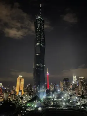 a tall skyscraper with a red light on it at night at Opus Residences Merdeka Tower 118 View in Kuala Lumpur