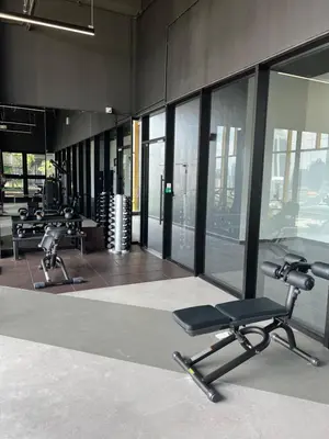 an empty gym with two chairs and windows at Opus Residences Merdeka Tower 118 View in Kuala Lumpur