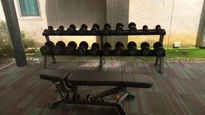 a bench with lots of dumbbells in a gym at Summer Suites Klcc by Malenehom in Kuala Lumpur