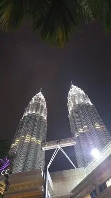 two tall buildings are lit up at night at Summer Suites Klcc by Malenehom in Kuala Lumpur