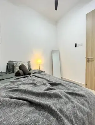 a bedroom with a bed with a gray blanket at Legasi Kampung Baru KL Homestay in Kuala Lumpur