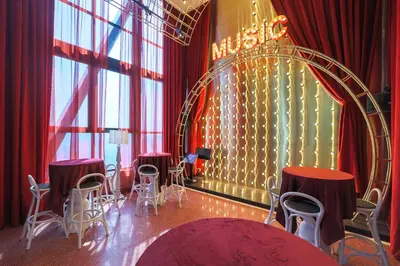 a room with red curtains and tables and chairs at Scarletz Suites KLCC by MyKey in Kuala Lumpur