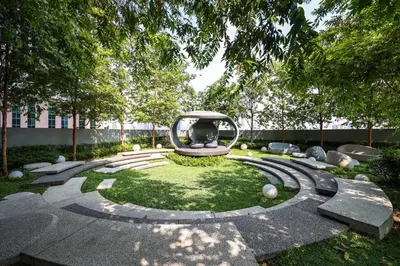 a garden with a circular sculpture on the grass at Scarletz Suites KLCC by MyKey in Kuala Lumpur