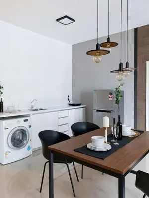 a kitchen and dining room with a wooden table and chairs at Stylish & Cozy 2BR Apt at Arte Plus, FREE Parking in Kuala Lumpur